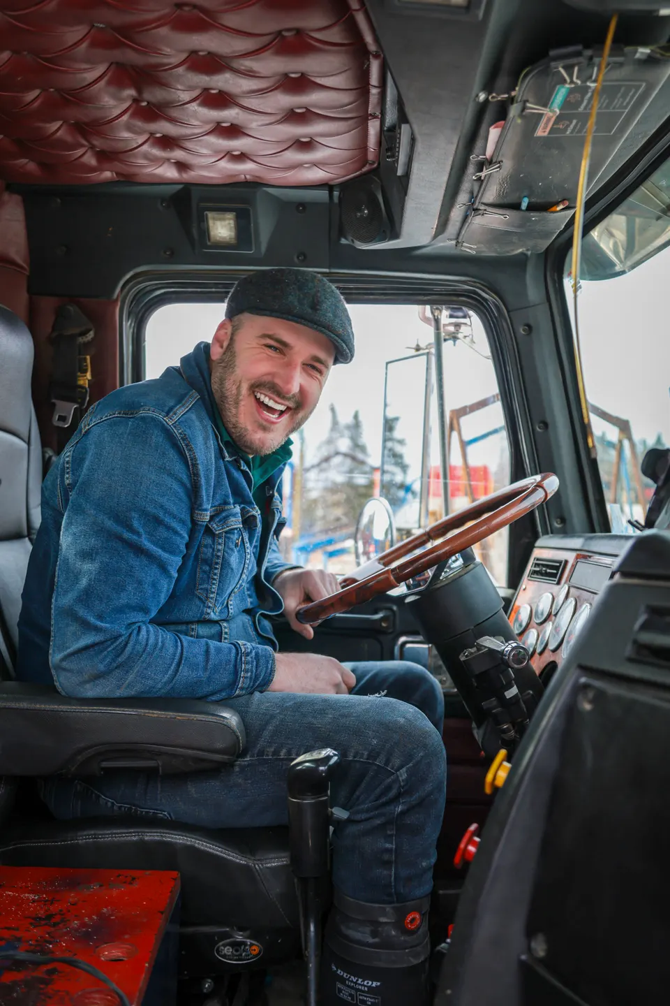 Operator smiling at the wheel of his truck on the job site.