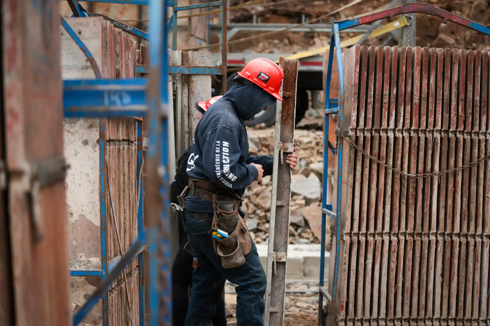 Travailleur circulant entre deux murs de coffrage montés.