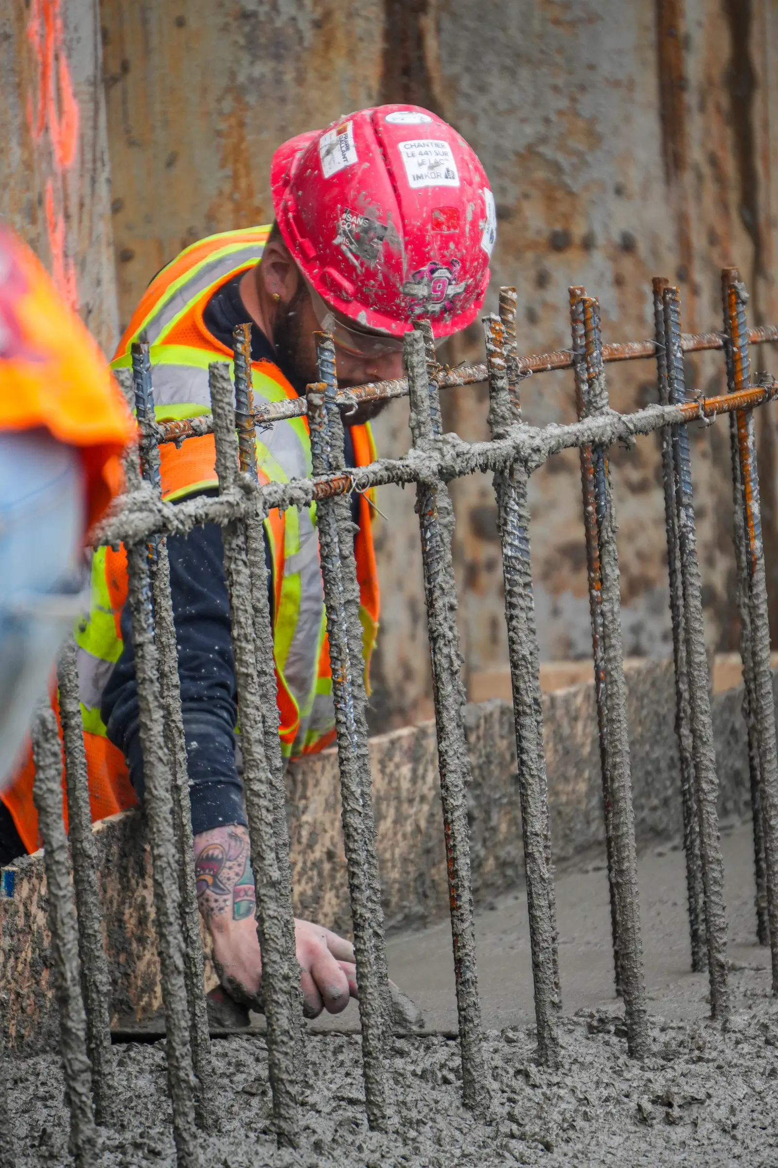 Worker leaning over the rebar during the concrete pour.