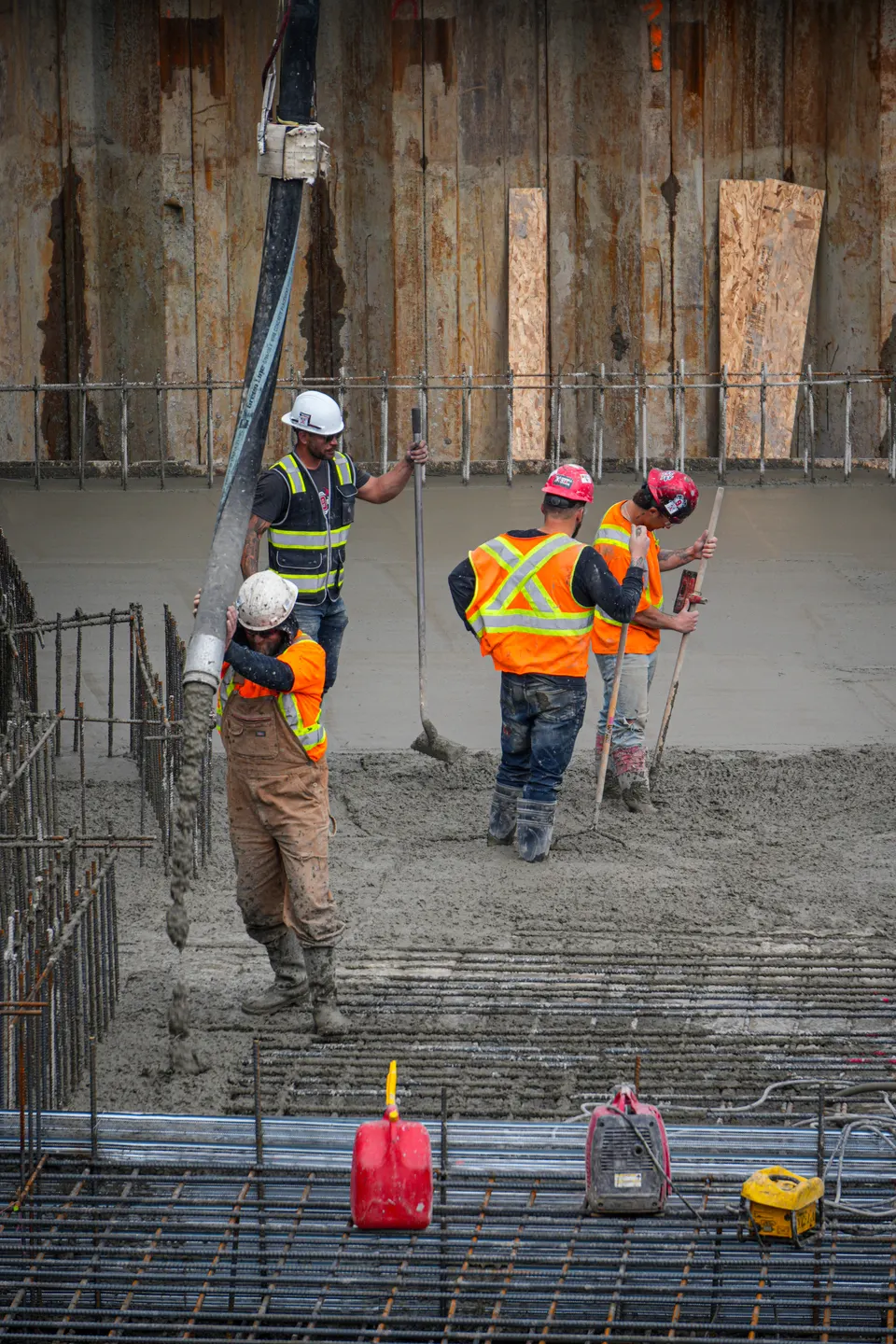 Pouring a structural slab: five workers spread around the concrete pump hose.